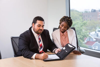 man a woman taking notes at a conference table